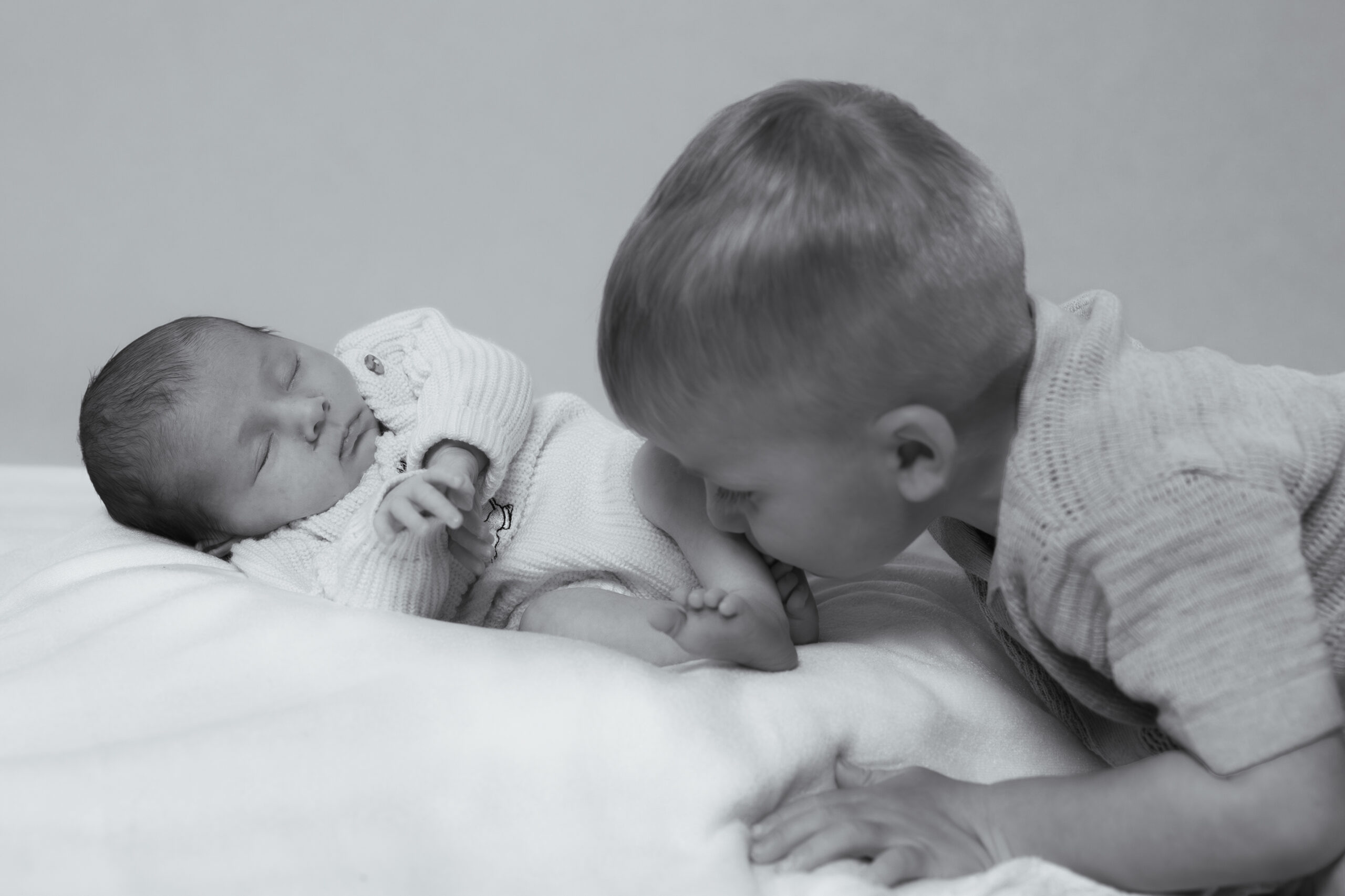 Big brother holding his newborn sibling in The Little Light Studio